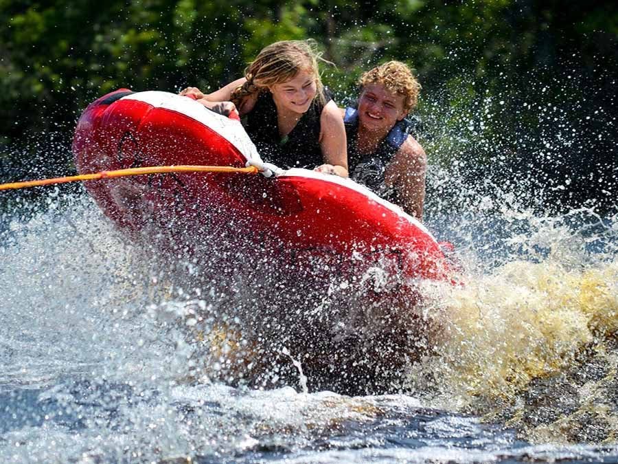 Kids in a raft being pulled by a boat