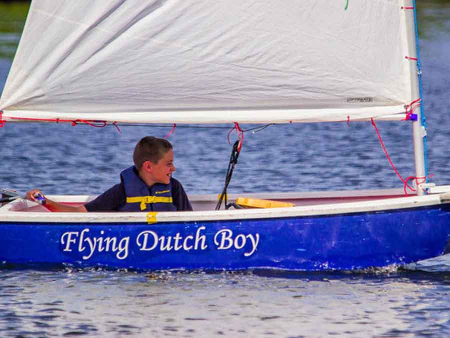 Young boy sailing his boat 'Flying Dutch Boy'