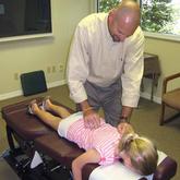 Dr. Parris adjusting young girl's back