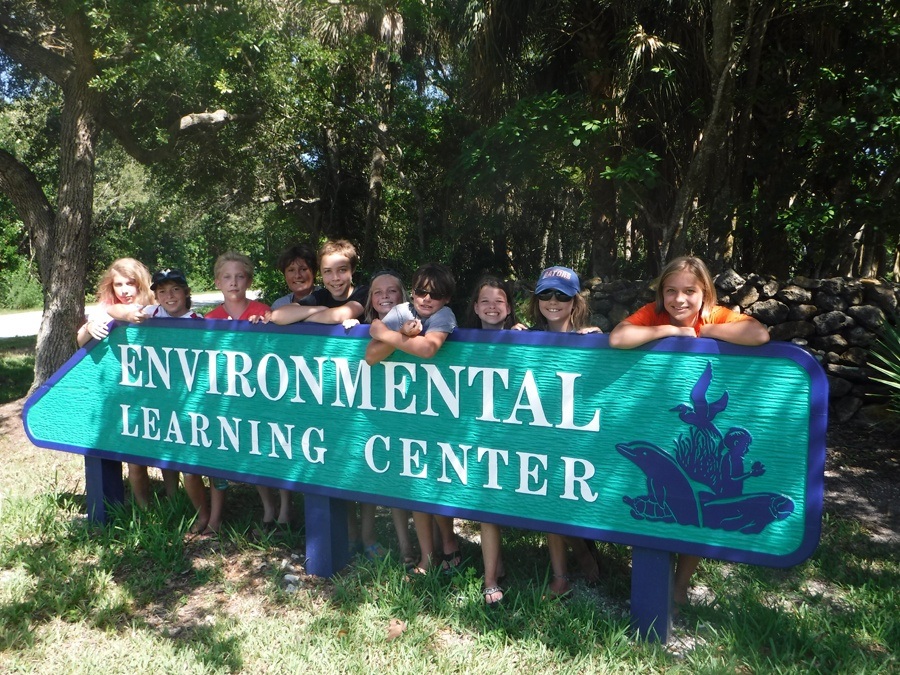 Children standing behind the Environmental Learning Center sign