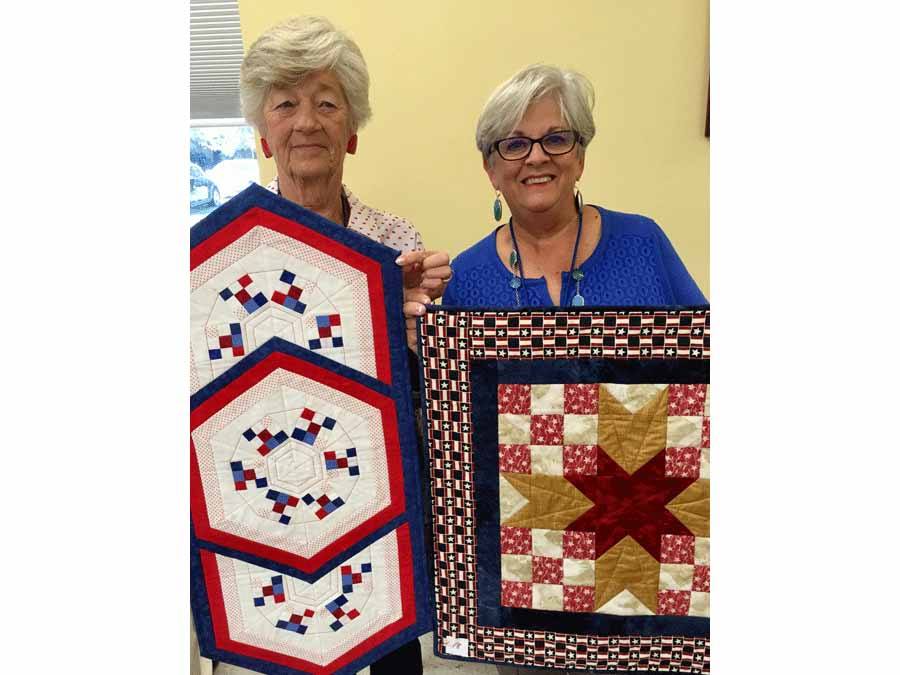Diane Larrabee and Linda Jackson showing items they made