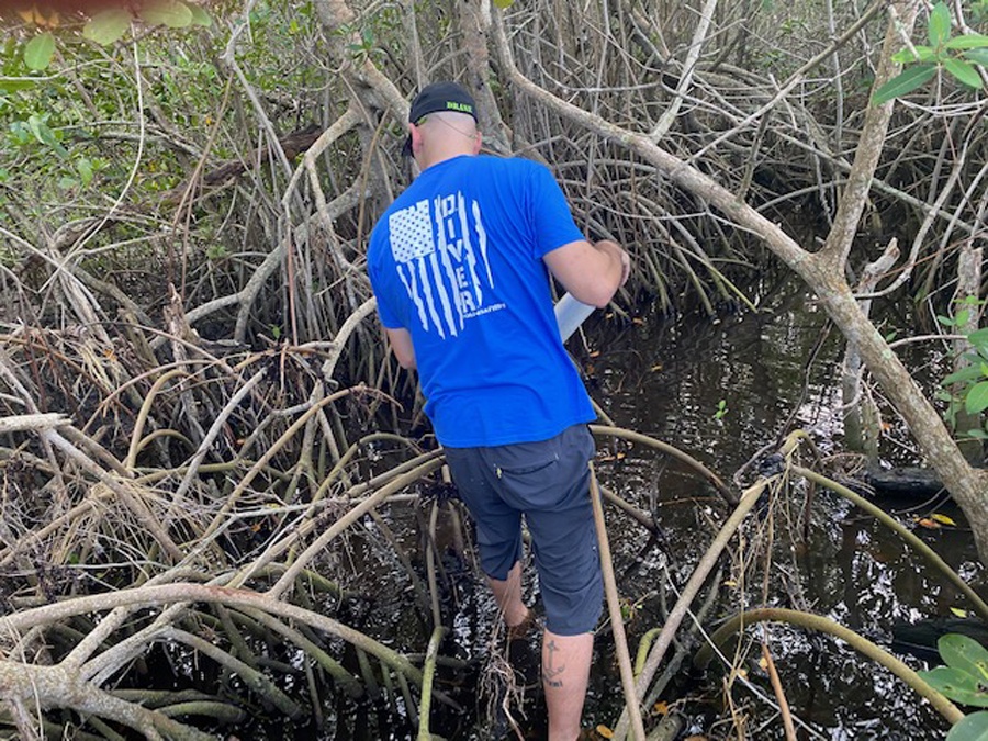 volunteer looking for waterway trash