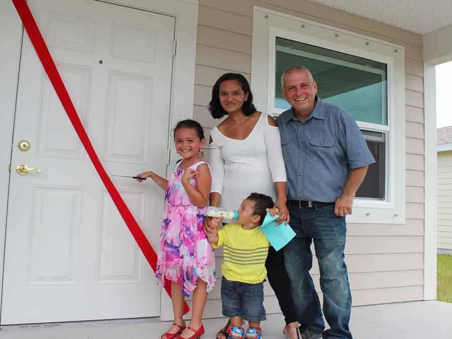 Family standing at front door of their new home