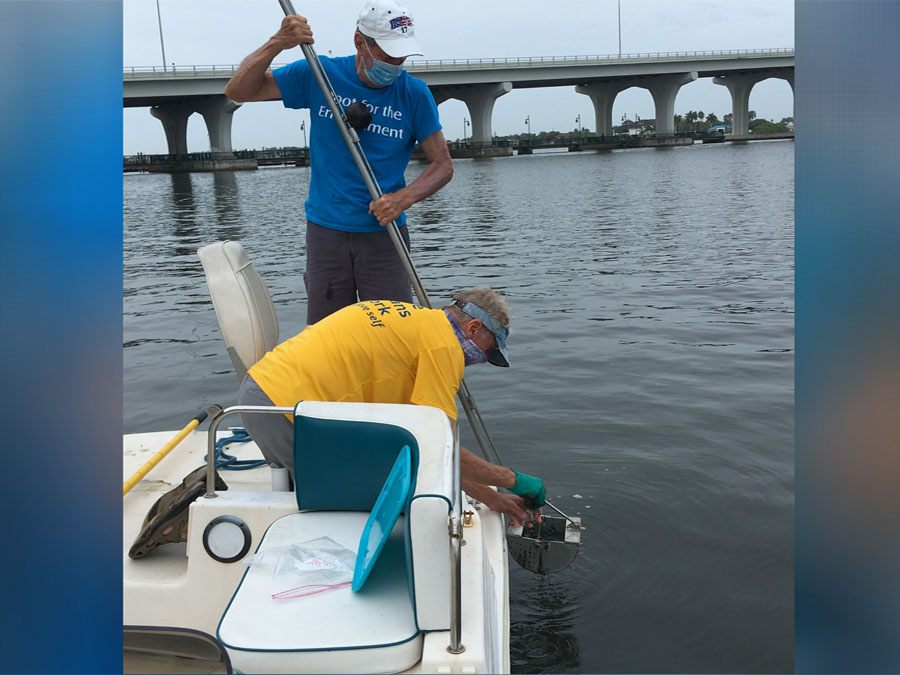 Men in boat reaching into water with monitoring equipment for ORCA in Vero Beach