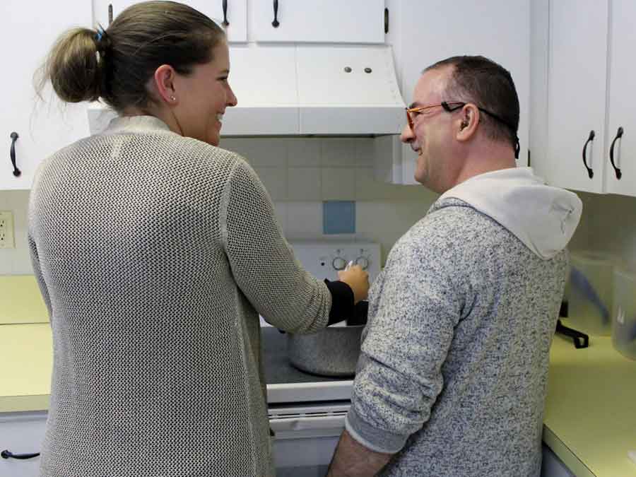 Woman teaching man cooking skills at home