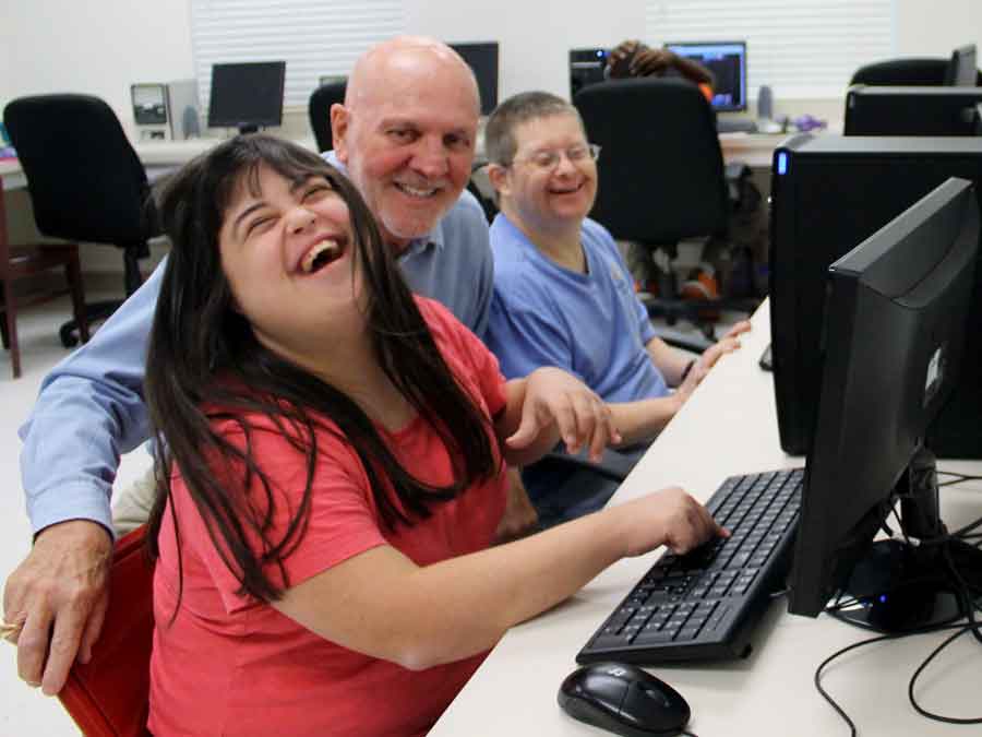 Woman laughing while learning to use the computer