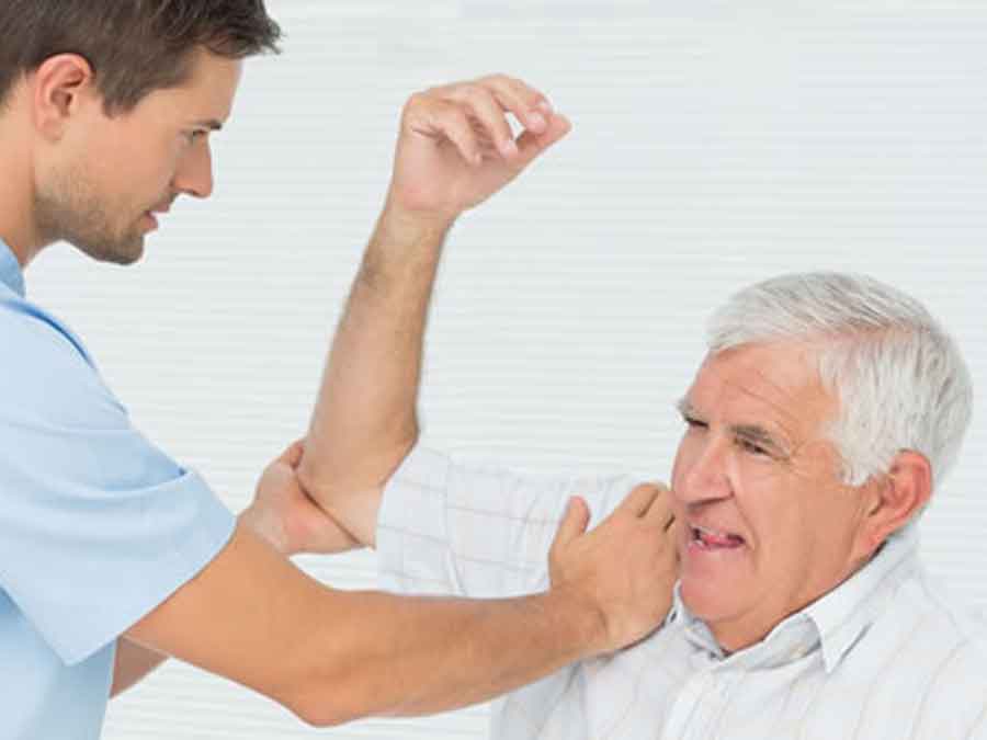 Male therapist stretching man's shoulder