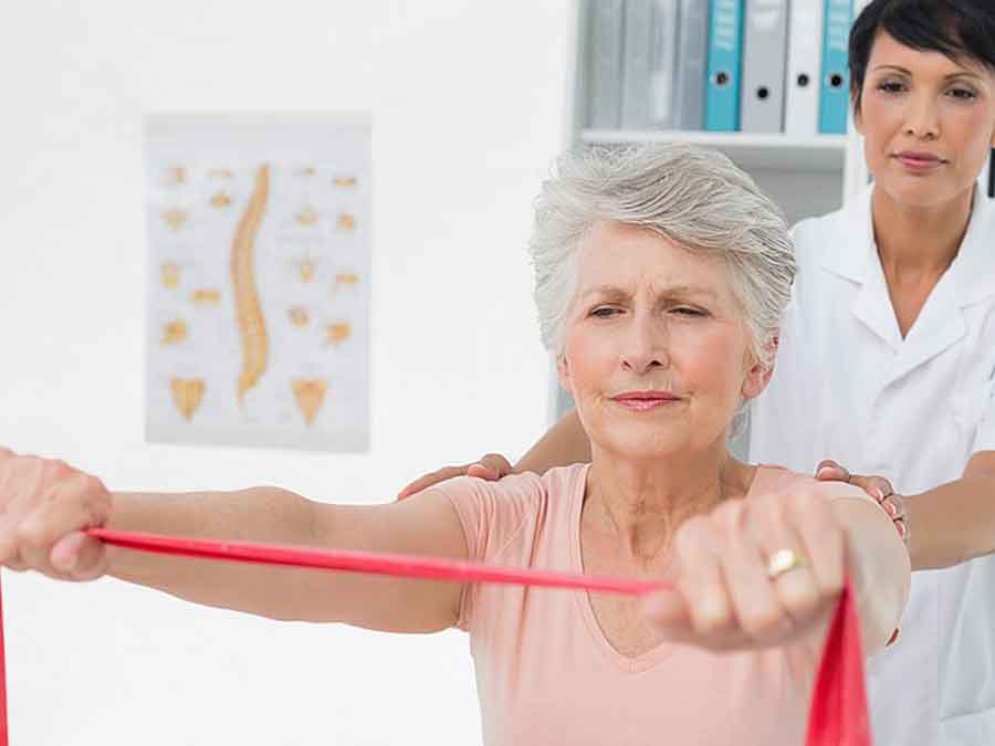 therapist teaching patient exercise with rubber band 